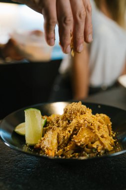 Genç aşçı çift modern bir restoranın mutfağında erişte pişiriyor.