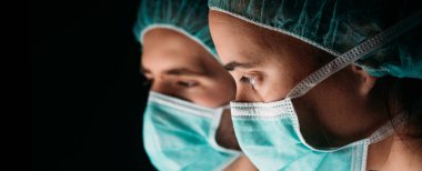 Kadın ve erkek doktor koruyucu yüz maskesi takıyor ve siyah arka planda koronavirüse karşı. Panorama panorama tıbbi personel önleyici ekipman. Doktor Coronavirus 'u izole et..