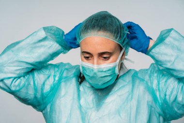 COVID-19 Koronavirüs salgını, tıbbi maske takan kadın doktor, lateks eldivenler ve virüse karşı koruyucu giysiler.