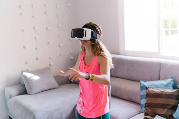 woman doing sport with virtual reality glasses at home