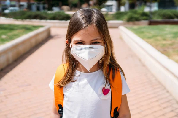 Bambina con maschera in un parco durante la pandemia di coronavirus — Foto Stock