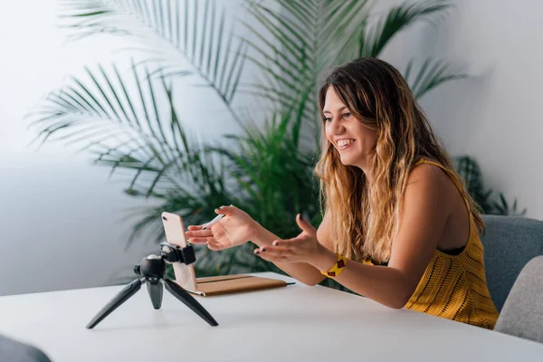 Mulher fazendo uma chamada de vídeo com seu smartphone em casa . — Fotografia de Stock