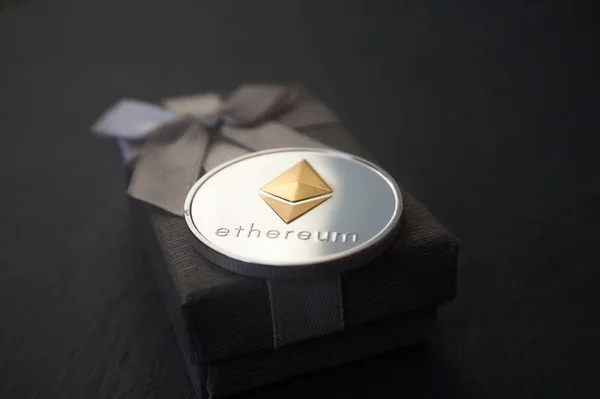 Gümüş Ethereum sikke üzerinde gri hediye kutusu yalan
