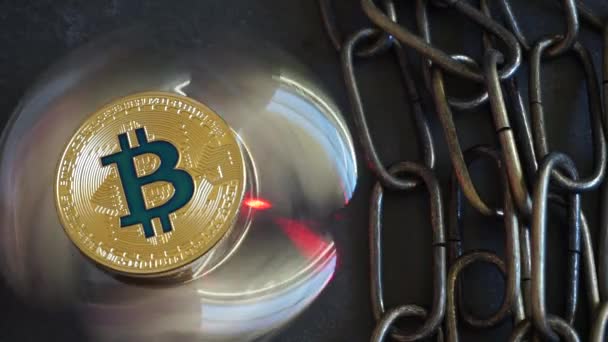 Kryptowährung Bitcoin, rotierende Spiegelfläche, roter Laser und Kette. — Stockvideo