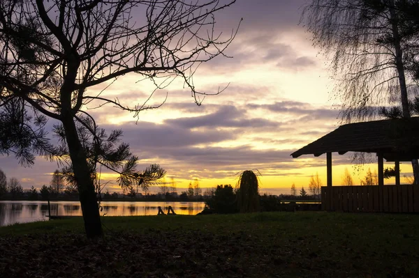 Tranquil lake reflecting a vivid orange sunset — Stock Photo, Image