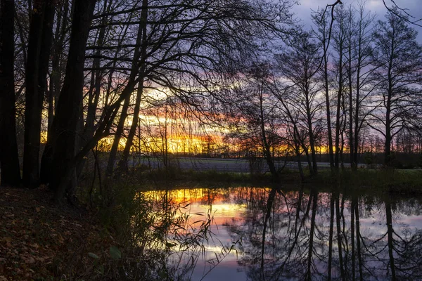 Reflection of a colorful sunset on a tranquil lake — Stock Photo, Image