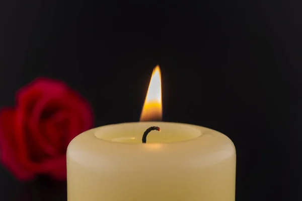 Yksi Palava Keltainen Kynttilä Punaisen Ruusun Vieressä Tummaa Taustaa Vasten — kuvapankkivalokuva