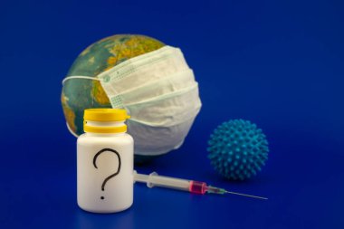 Derialtı şırıngası, ilaç şişesi ve mavi virüs molekülü içeren bir Covid-19 aşısı için araştırma kavramı. Bir kürenin önünde, üzerinde koruyucu yüz maskesi olan mavi bir arka planda fotokopi alanı olan bir dünya.