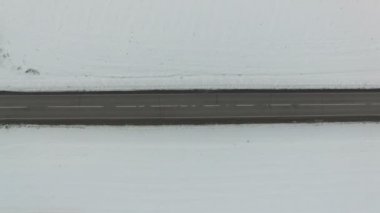 Otomobil ve kamyon sürüş bir yolda kış gününde hava dikey atış. Drone yol aşağı taşır.