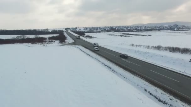 Plano aéreo de los coches y camiones que conducen en una carretera en el día nublado de invierno . — Vídeo de stock