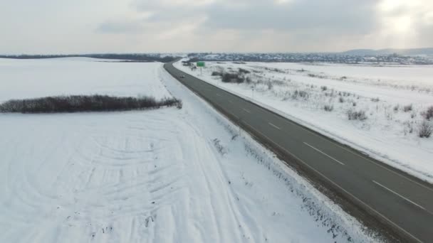Plano aéreo de los coches y camiones que conducen en una carretera en el día nublado de invierno . — Vídeos de Stock
