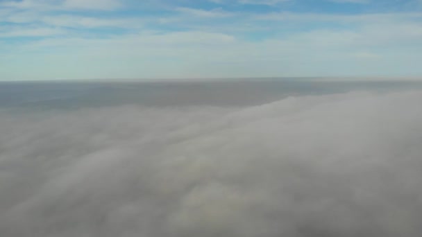 Über Wolken fliegen. Videoaufnahmen per Drohne am frühen Morgen. Smog über der Stadt. Blick auf die Kuppel der Kirche durch Wolken. Echtzeit-Aufnahmen. — Stockvideo