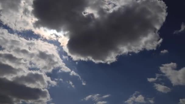 Superbe laps de temps 4K. Les rayons du soleil traversent des nuages blancs et duveteux sur un ciel bleu vif 