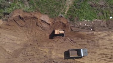 İnşaatın ilerisindeki buldozer düzleştirme yüzeyinin üst hava görüntüsü. Boş bahşişçi arabayla geliyor.