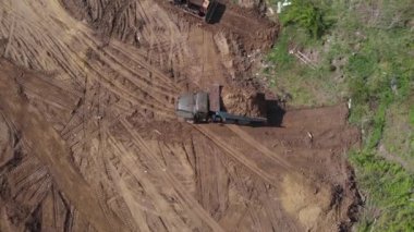 Bahşiş verenin havadan çekim alanı daha ileri inşaat sahasına boşaltması. Buldozer düzleştirme yüzeyinin yanında. 4K.