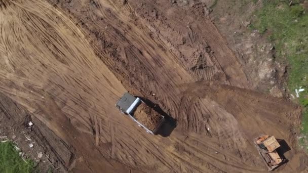 Vista aérea superior de la superficie de aplanamiento de la excavadora en el sitio de construcción posterior — Vídeos de Stock