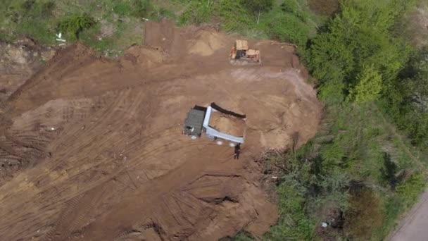 Plano aéreo del volquete que descarga el terreno en el sitio de construcción adicional . — Vídeos de Stock