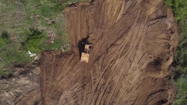 Górny widok z powietrza na powierzchnię spłaszczającą buldożera na dalszym placu budowy — Wideo stockowe