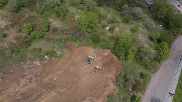 Plano aéreo del volquete que descarga el terreno en el sitio de construcción adicional . — Vídeo de stock