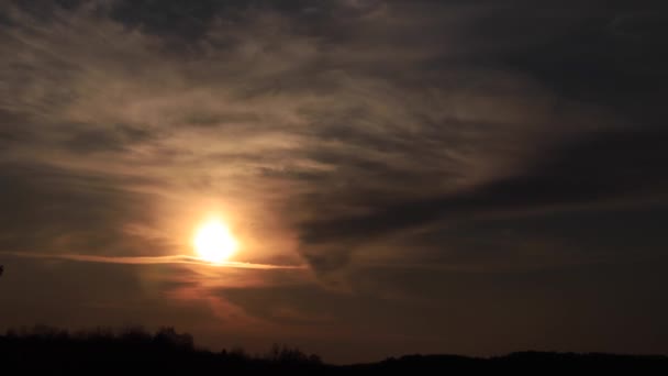 Time lapse coucher de soleil étonnant brillant à travers des nuages mous allant à l'obscurité. 4K 