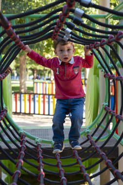 Halat parkında oynayan iki yaşında bir çocuk var.