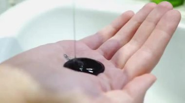 Siyah duş jeli el dışarı akar