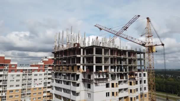 Construção de um edifício residencial de vários andares, dois trabalhos de guindastes — Vídeo de Stock