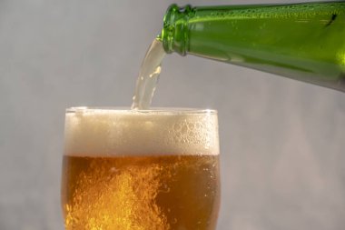Şişeden bardağa bira dolduruyorum.
