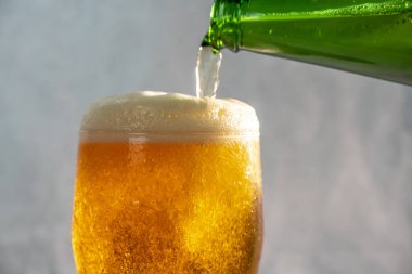 Şişeden bardağa bira dolduruyorum.