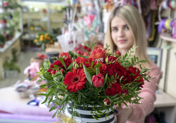 Una chica, una florista diseñadora, sostiene un hermoso ramo festivo. — Foto de Stock