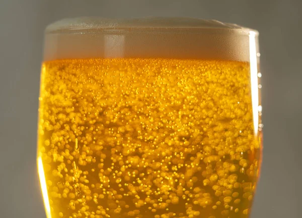 啤酒特写杯中的光芒中的气泡和泡沫 — 图库照片
