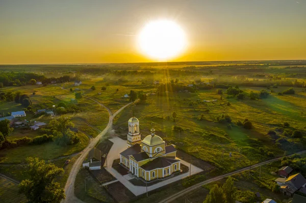 Blick vom Quadrocopter auf das Dorf in der untergehenden Sonne — Stockfoto