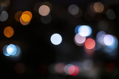 Siyah zemin üzerinde çok renkli çemberler şeklinde soyut bokeh arkaplanı.