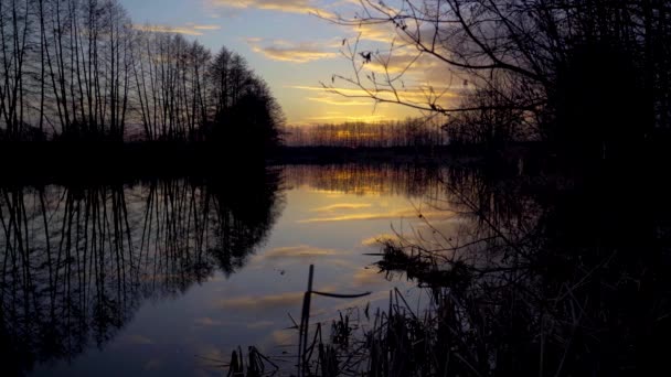 Vídeo timelapse de una hermosa puesta de sol naranja en un río de primavera — Vídeos de Stock
