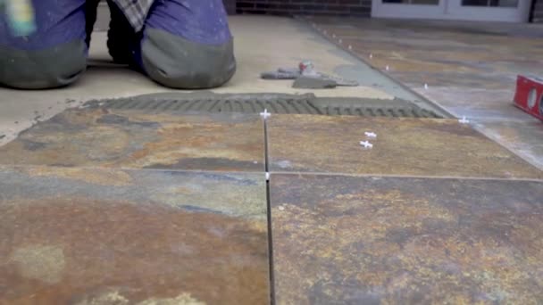 Pose de carreaux de céramique sur le sol, nivellement des carreaux posés en utilisant le niveau de construction — Video