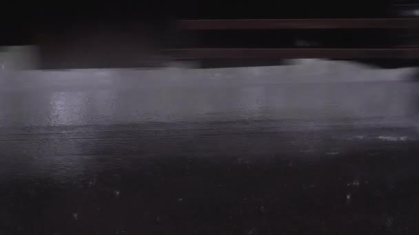 Lente zware regen, regendruppels vallen op de weg bedekt met zwart asfalt, auto wielen passeren spetterend water en laat sporen na op het asfalt, slow motion — Stockvideo