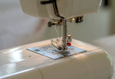 Bir dikiş makinesinin, bir faytonun ve dolu bir dikiş iğnesinin ayrıntıları.