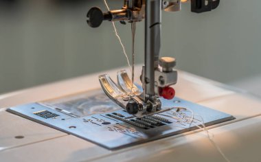 Bir dikiş makinesinin, bir faytonun ve dolu bir dikiş iğnesinin ayrıntıları.