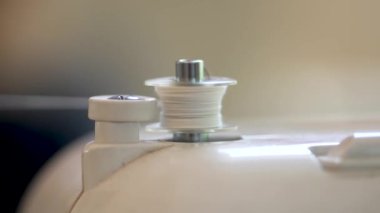 Dikiş makinesine dikiş dikiyorum. Beyaz ipliğin sarmalandığı yakın plan görüntüsü