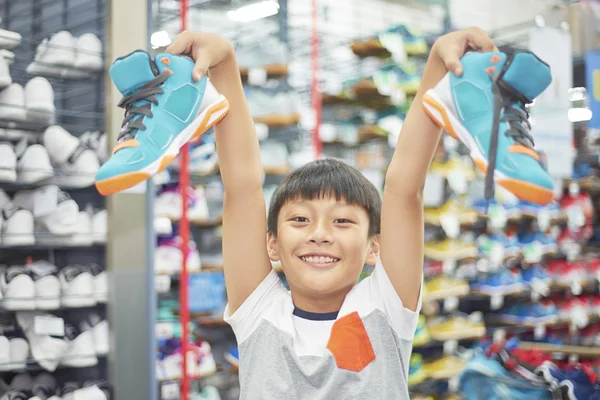 Niño sosteniendo zapatos elegidos — Foto de Stock