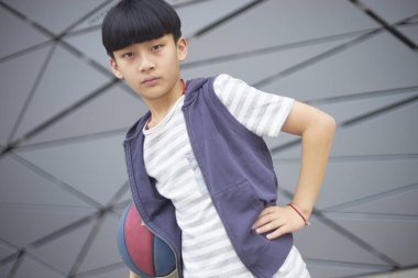 Basketbol açık havada tutan güzel Asyalı çocuk portresi