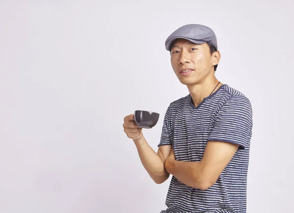 Asiatico uomo sorridente a camera holding caffè tazza isolato — Foto Stock