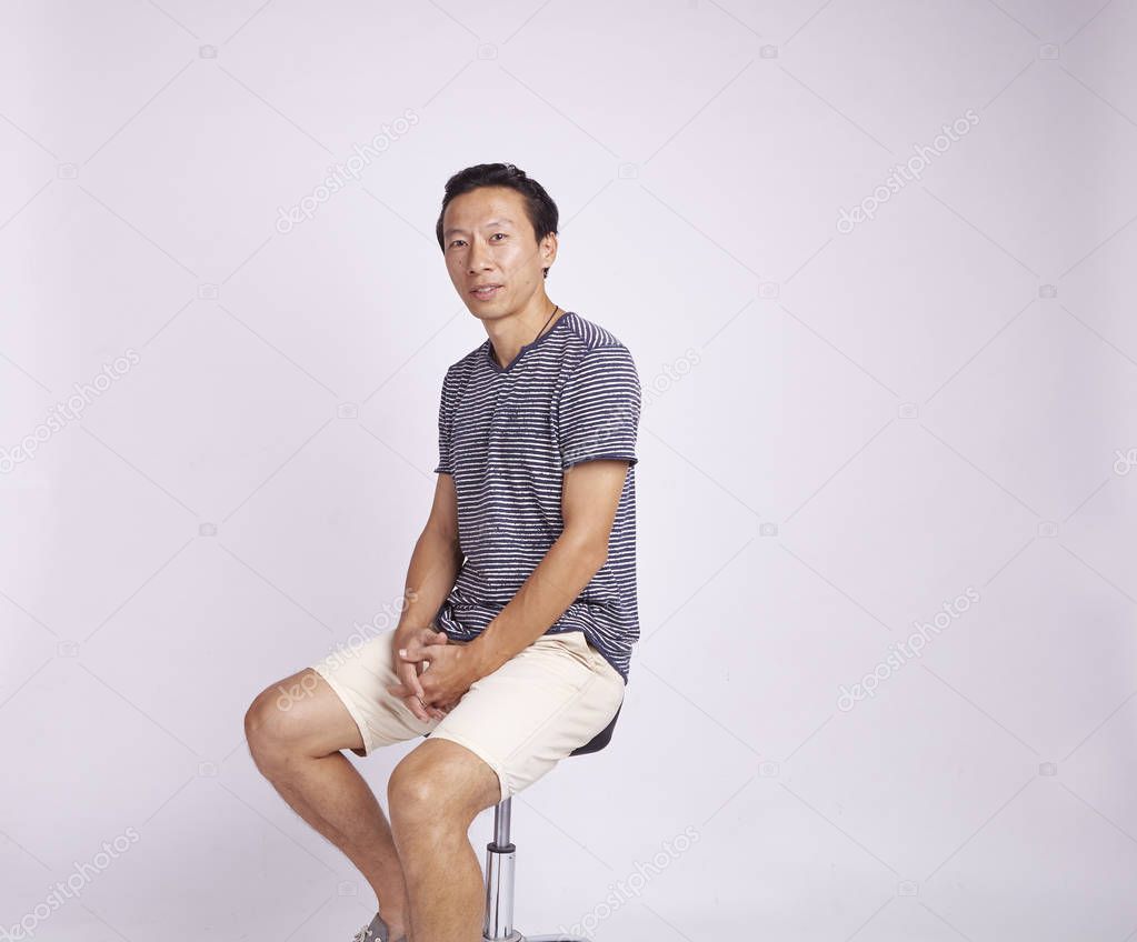 Asian adult sitting on stool isolated on white