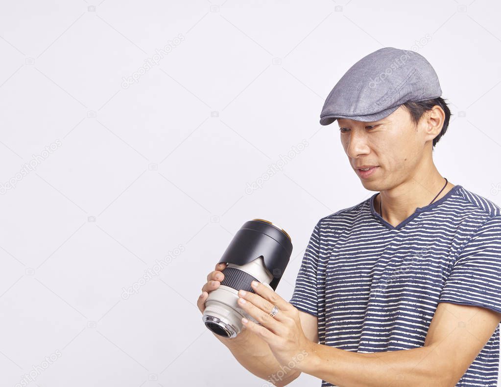 Asian photographer checking lens isolated on white