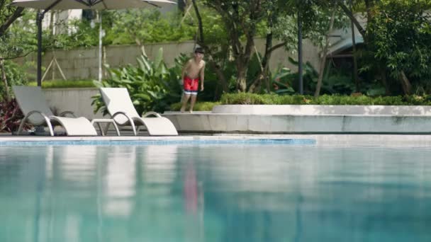 亚洲青少年在花园慢跑跳进游泳池 — 图库视频影像
