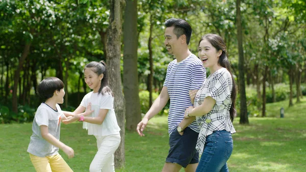 Chinese parents and kids enjoying weekend activity in park in summer