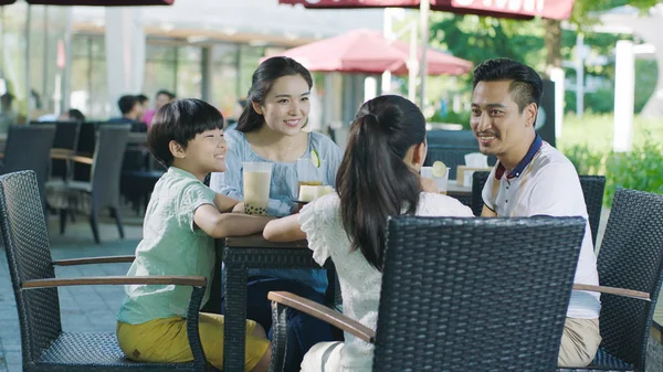アジアの家族の笑顔、食べて・飲んでストリート ビューのテーブルで屋外 — ストック写真