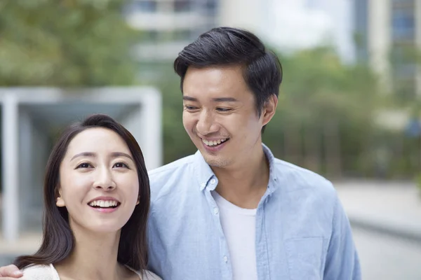 Portrait of young Chinese couple standing & smiling outdoor — Stock Photo, Image