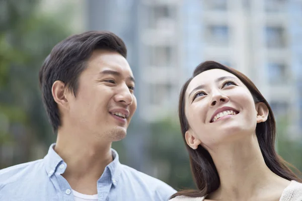portrait of young Chinese couple standing & smiling outdoor in garden