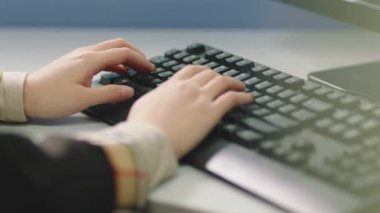 closeup of hand typing on computer keyboard in office